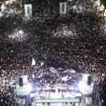 Multitud de personas disfrutando del show en vivo de la banda Tarea Fina en la costa de Punta Lara durante un recital al aire libre.