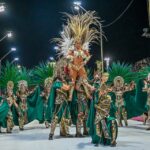 Comparsa Marí Marí desfilando en el Carnaval 2026 de Brandsen ante una multitud sobre la avenida Mitre.