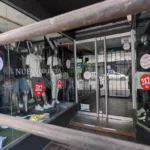 Vidriera de local de ropa en el centro de La Plata con cartel de liquidación por cierre y descuentos del 50%.